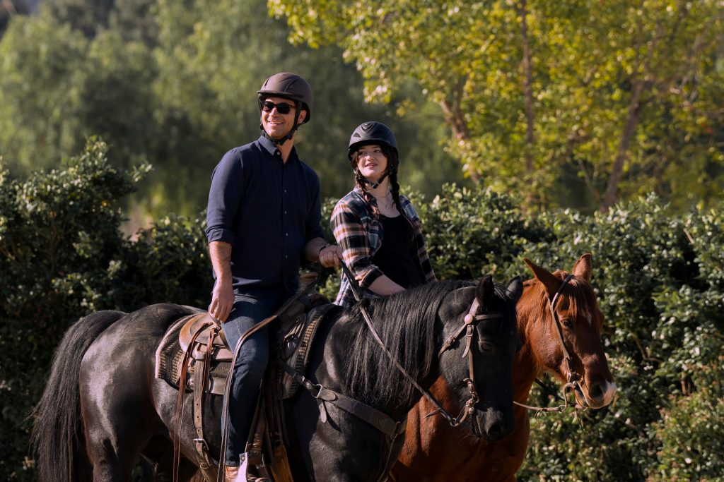 The Lincoln Lawyer characters Mickey and Hayley each on horseback.