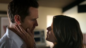 The Lincoln Lawyer character Maggie faces character Mickey Haller and holds her hand on his right cheek.