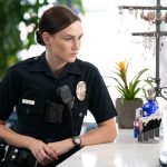 Bosch: Legacy Season 2 character Maddie Bosch in police uniform leaning on desk